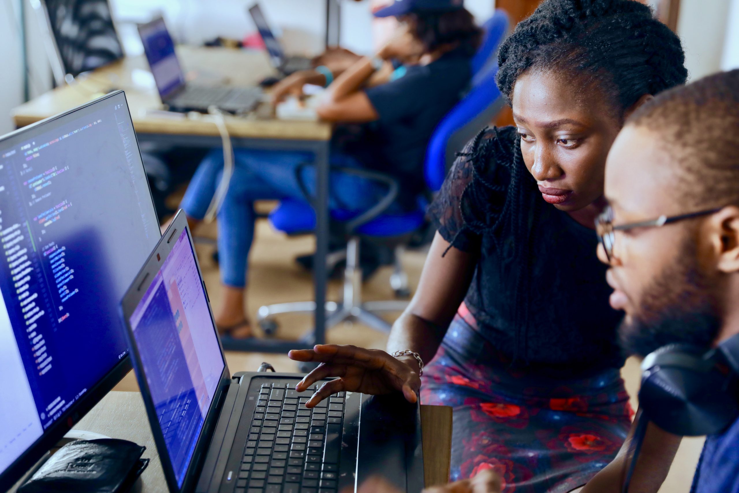 Black woman and man at computer with code